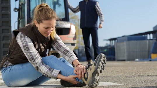 woman on floor holding her ankle that is hurt